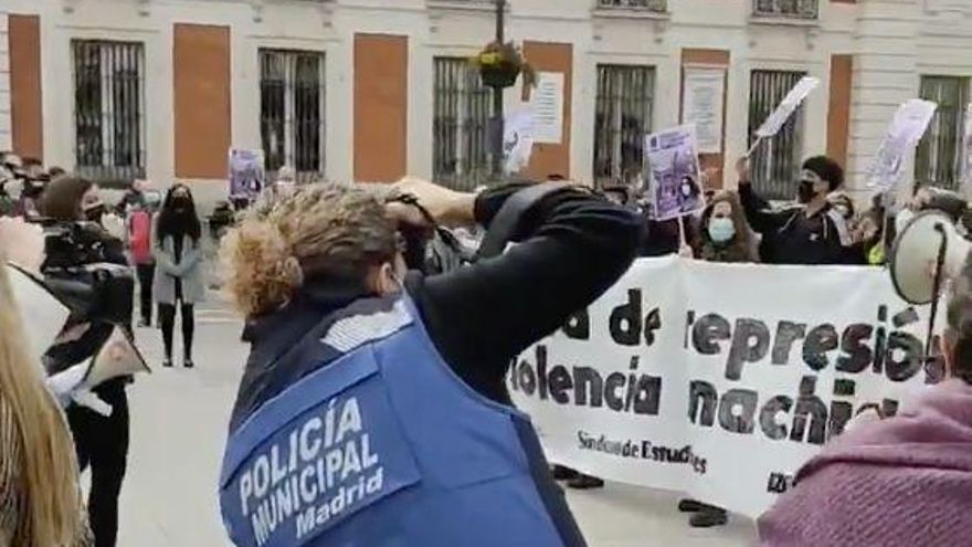 Una agente de la Policía Municipal toma fotos en la concentración del 8M en Sol