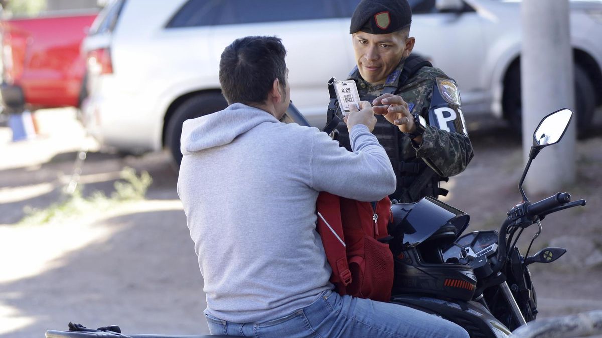 Un integrante de la Policía Militar de Honduras revisa el documento de un ciudadano este viernes, en Tegucigalpa.
