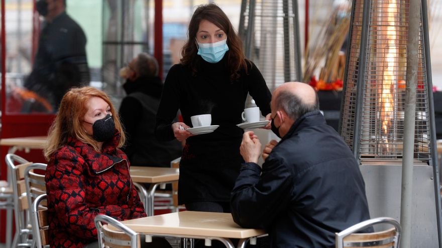 Una camarera sirve a dos clientes en una terraza de Valencia. EFE/Kai Försterling