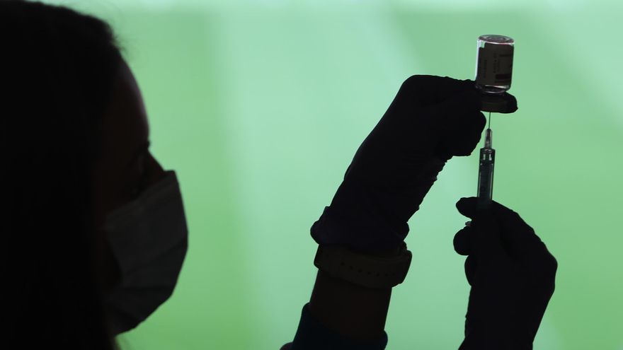 Un profesional sanitaria sostiene una jeringuilla y un vial con la vacuna del Covid-19