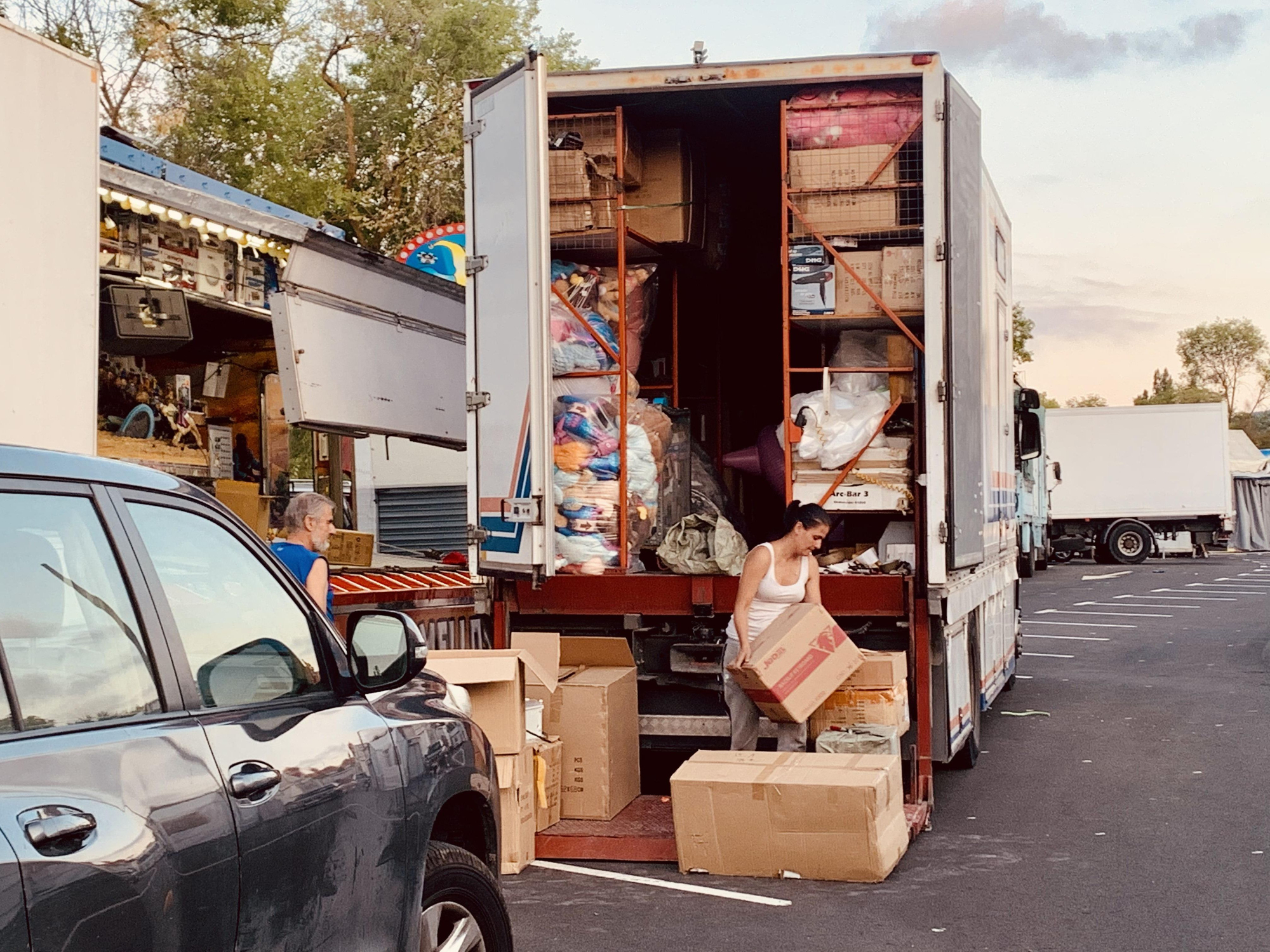 Una mujer descarga un camión lleno de peluches para una tómbola