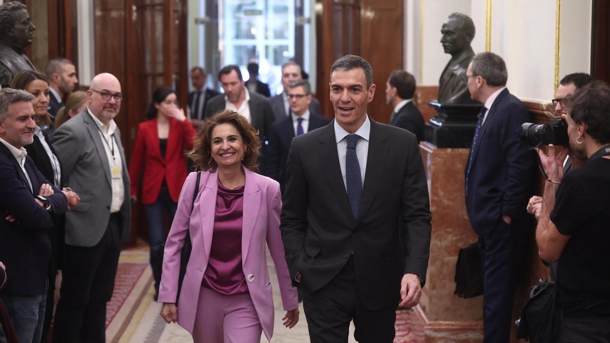 La vicepresidenta primera del Gobierno, María Jesús Montero, y el presidente, Pedro Sánchez,  a la entrada del hemiciclo antes de la votación del decreto anticrisis por la guerra en Irán