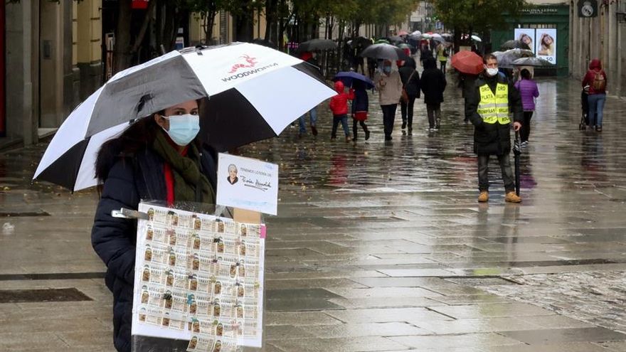 Una lotera ambulante vente lotería de Doña Manolita en la Puerta del Sol.