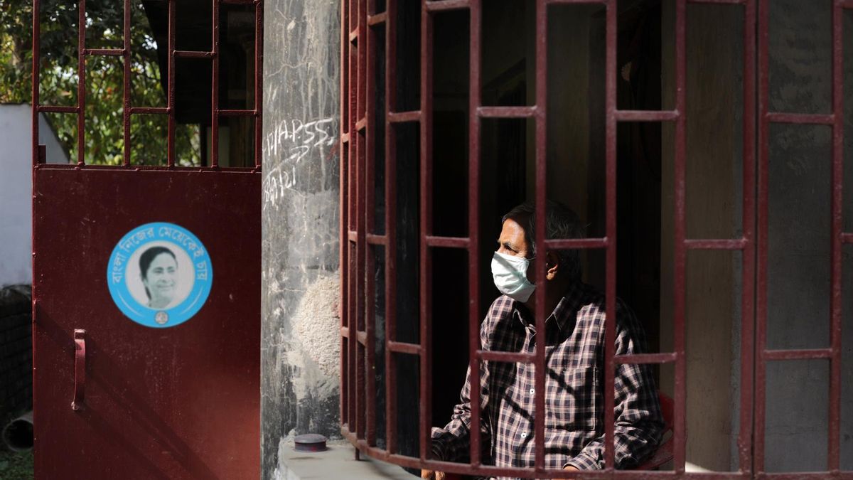 A man looks out from a window during a 24-hour lockdown in Kolkata, India, 17 January 2022. The Bengal government announced the weekly lockdown in different places of district towns and Kolkata to combat Covid 19 crisis in India.