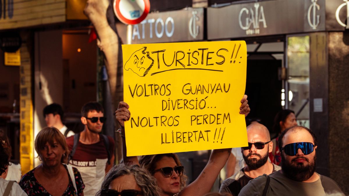 Una pancarta amb el lema "Turistes, vosaltres guanyau diversió, noltros perdem llibertat".