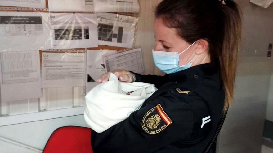 Una agente con el bebé encontrado en un carro de supermercado en Ávila.