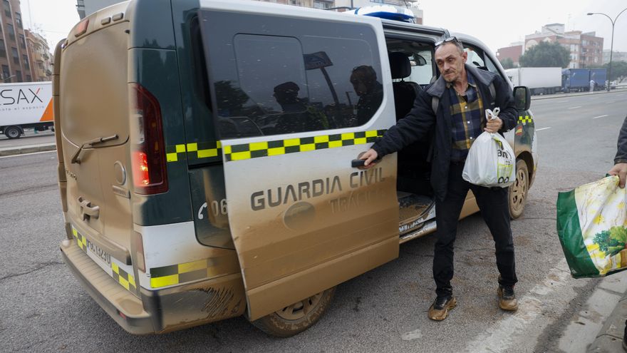 Una persona rescatada de una de las zonas afectadas por las inundaciones baja de un coche de la Guardia Civil en la ronda Sur de la València