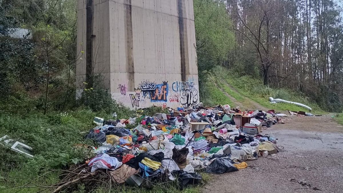 Basurero ilegal bajo el puente de la A-8 junto a la ría Agüera.