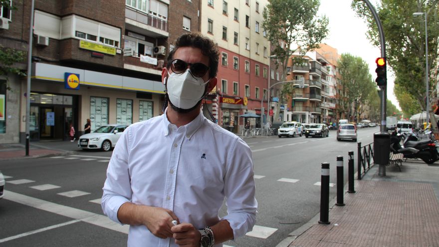 José Miguel, un trabajador de la moda, aguarda el bus en el barrio de Carabanchel tras anularse el cierre de Madrid.