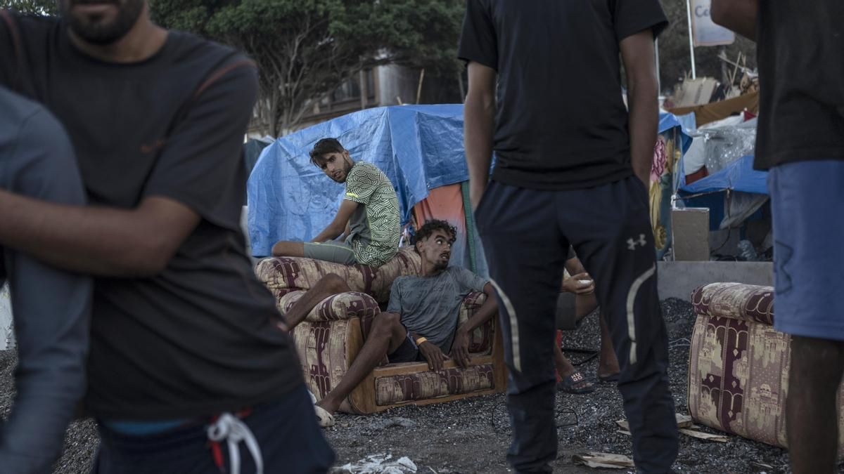 Imagen de archivo. Dos migrantes marroquíes descansan en un sofá en el campamento provisional de migrantes de la playa de El Trampolín, donde se estima que residen más de 2.000 personas, según las últimas cifras registradas el 24 de septiembre de 2026 en Ceuta, España.