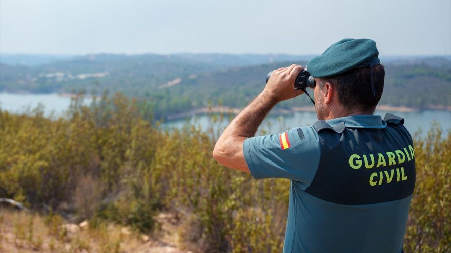 Agente de la Guardia Civil vigilan las zonas desalojadas del incendio de Niebla