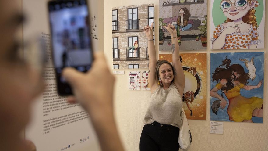 Una de las autoras de la exposición 'Ilustradoras & Ilustradas' posa junto a su obra durante la inauguración de la muestra