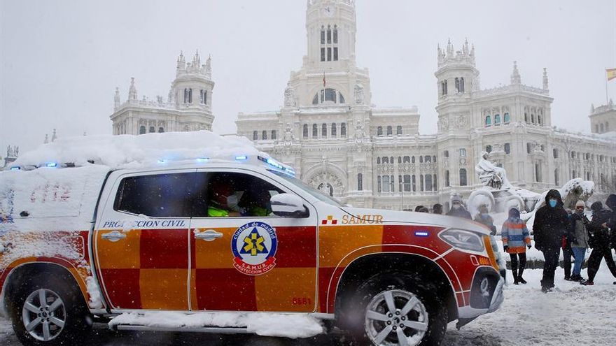 Un vehículo del Samur circula sobre la nieve por la plaza Cibeles de Madrid, este sábado
