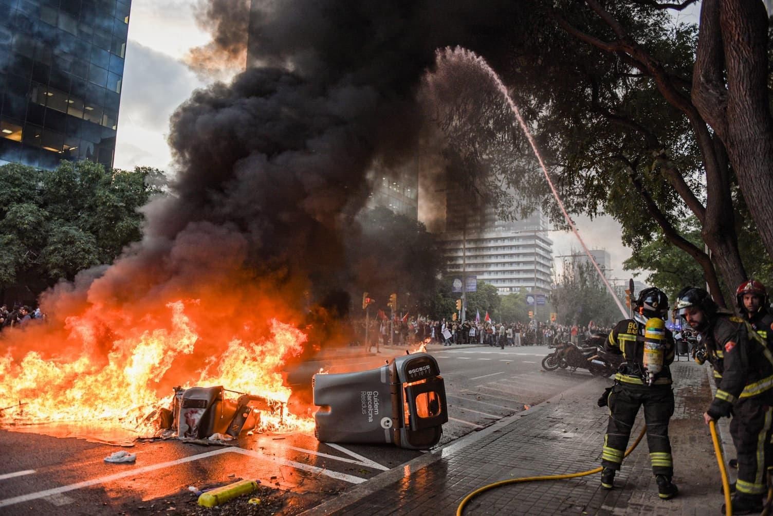 Los Bomberos de Barcelona apagan una de las barricadas que han ardido en el barrio de Sants durante la manifestación propalestina