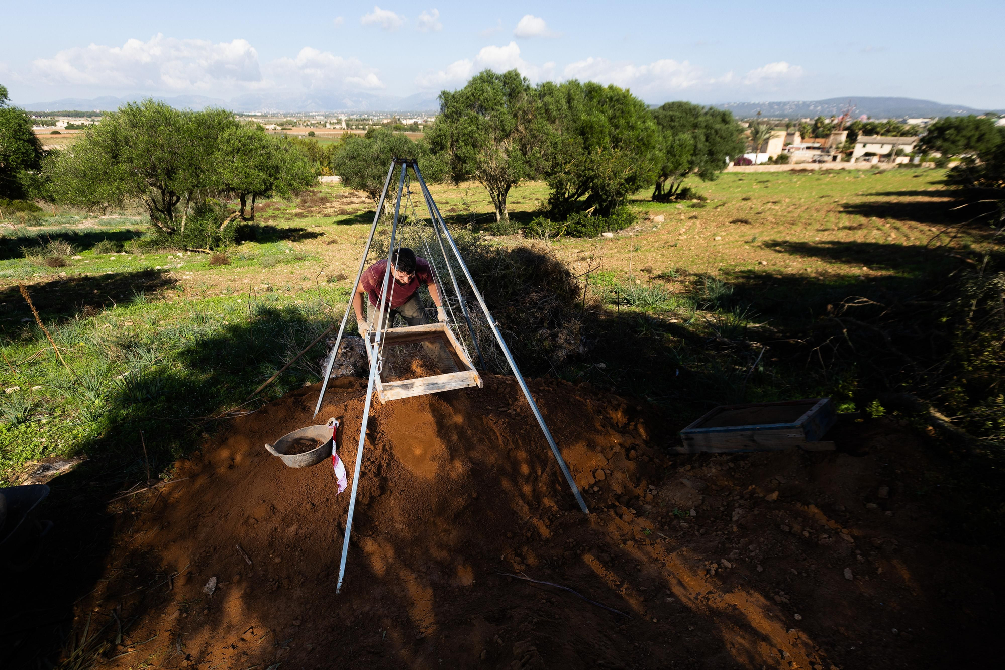Un arqueólogo criba la tierra extraída durante las excavaciones de Son Sunyer para recuperar pequeños restos arqueológicos