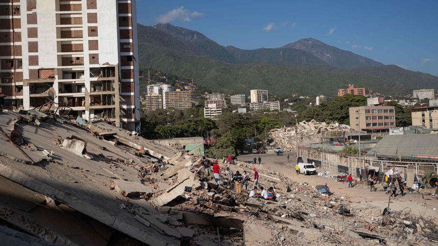 Personas observan los escombros de un edificio este lunes, en La Guaira (Venezuela). EFE/ Ronald Peña R