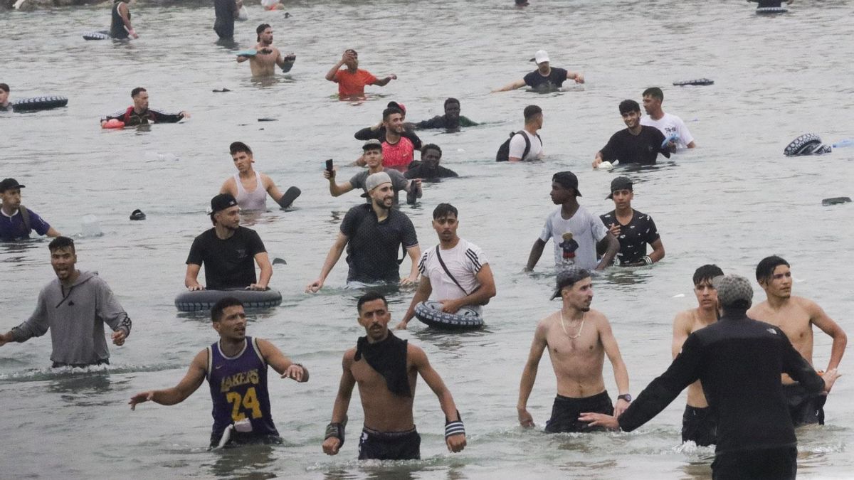 Un grupo de inmigrantes llega a la playa junto al paso fronterizo del Tarajal en Ceuta en la mañana del 31 de julio.