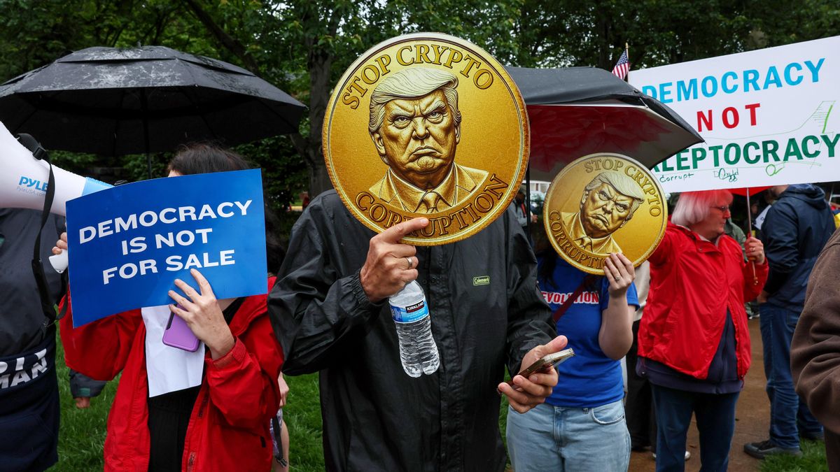 Manifestantes sostienen criptomonedas simuladas durante la concentración "América no está en venta", contra los tratos cripto amigos de Trump en el Trump National Golf Club el 22 de mayo de 2025 en Washington, DC.