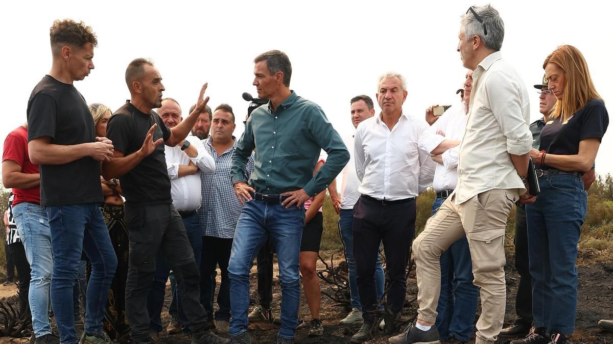 El presidente del Gobierno, Pedro Sánchez en una visita a Villablino en los incendios junto al ministro del Interior, Fernando Grande-Marlaska; y el delegado del Gobierno en Castilla y León, Nicanor Sen (ambos de blanco) junto a otros cargos políticos y vecinos