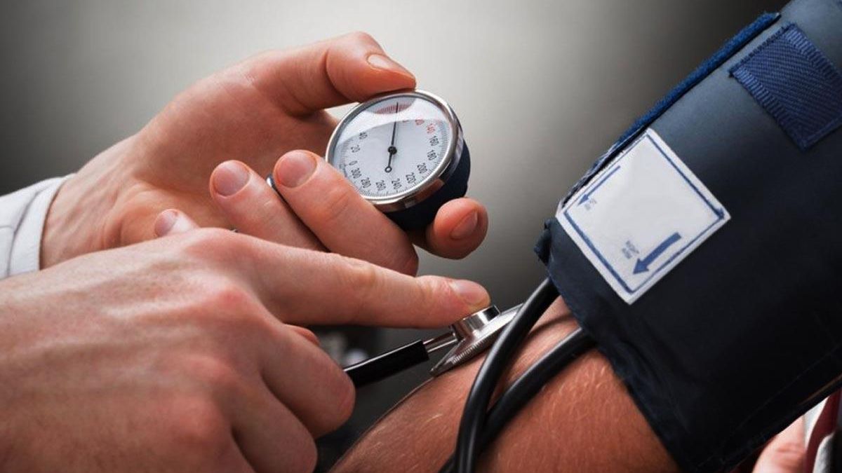 Un médico mide la presión arterial de un paciente