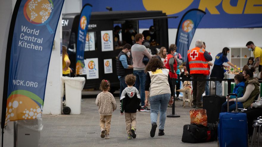 Archivo - Dos niños con una voluntaria traductora, en el centro de refugiados ucranianos, en la Fira de Barcelona, a 8 de abril de 2022