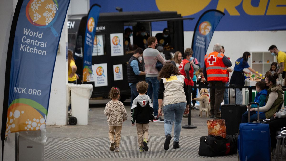 Archivo - Dos niños con una voluntaria traductora, en el centro de refugiados ucranianos, en la Fira de Barcelona, a 8 de abril de 2022