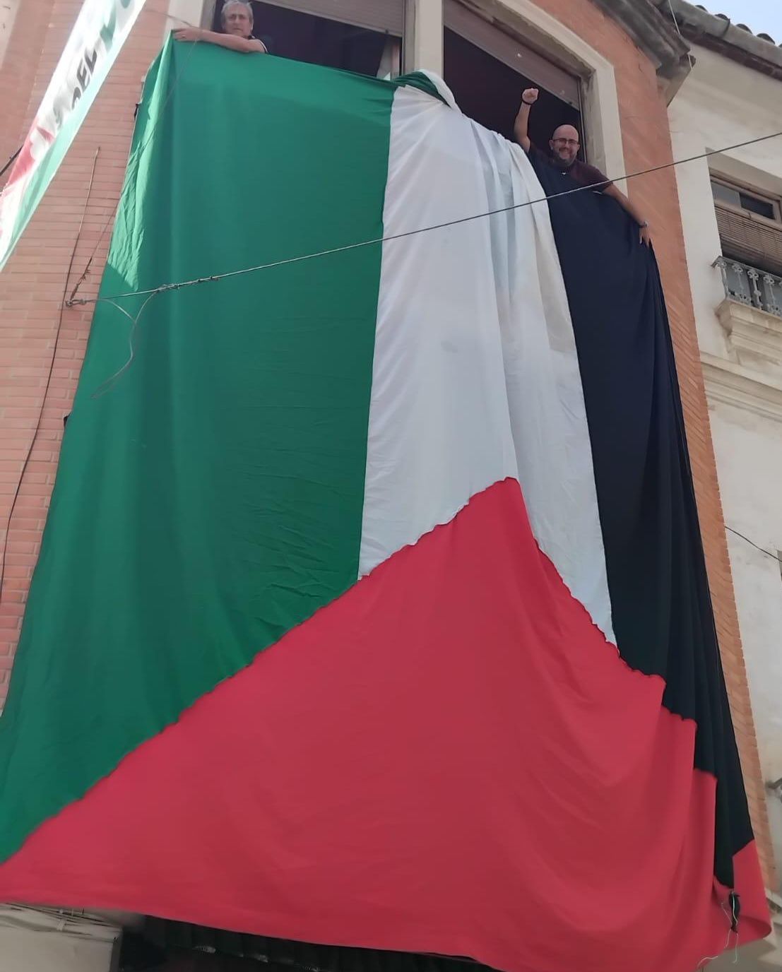 Una bandera gigante de Palestina ubicada junto al recorrido de la Tomatina.