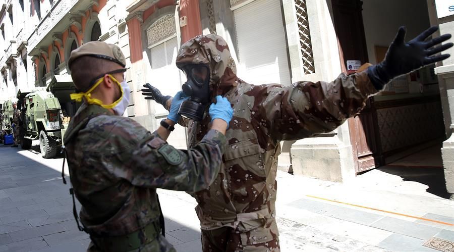 Efectivos del Ejército de Tierra, con trajes de protección, realizan labores de desinfección en el centro de salud de la zona centro de Santa Cruz