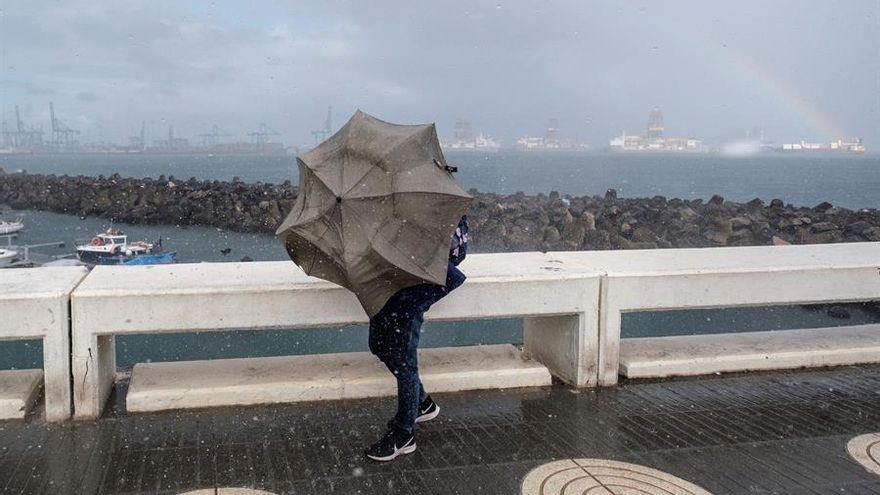 Una persona intenta avanzar ante el fuerte viento y la lluvia en la capital grancanaria