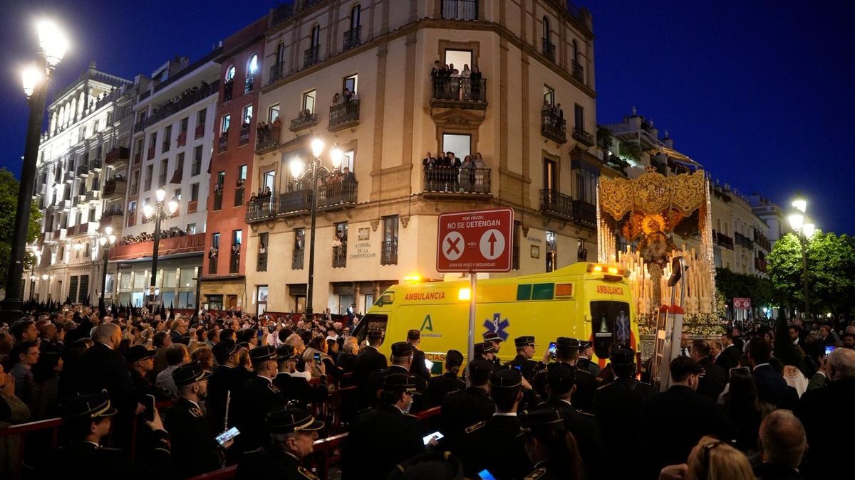 Una ambulancia atraviesa la avenida de la Constitución durante el tránsito de las cofradías en Sevilla