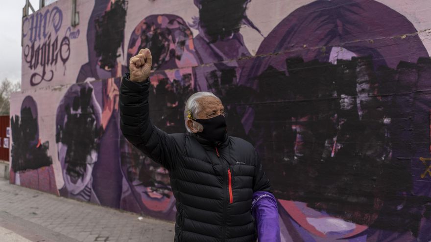 Un vecino levanta el puño frente al mural feminista de Ciudad Lineal