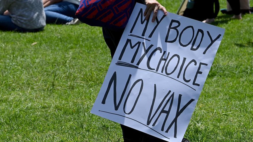 Protesters hold placards during a #ReclaimTheLine rally, dubbed 'Face the Music', against vaccine mandates and vaccine passports in Sydney, Australia, 12 December 2021. (Protestas)