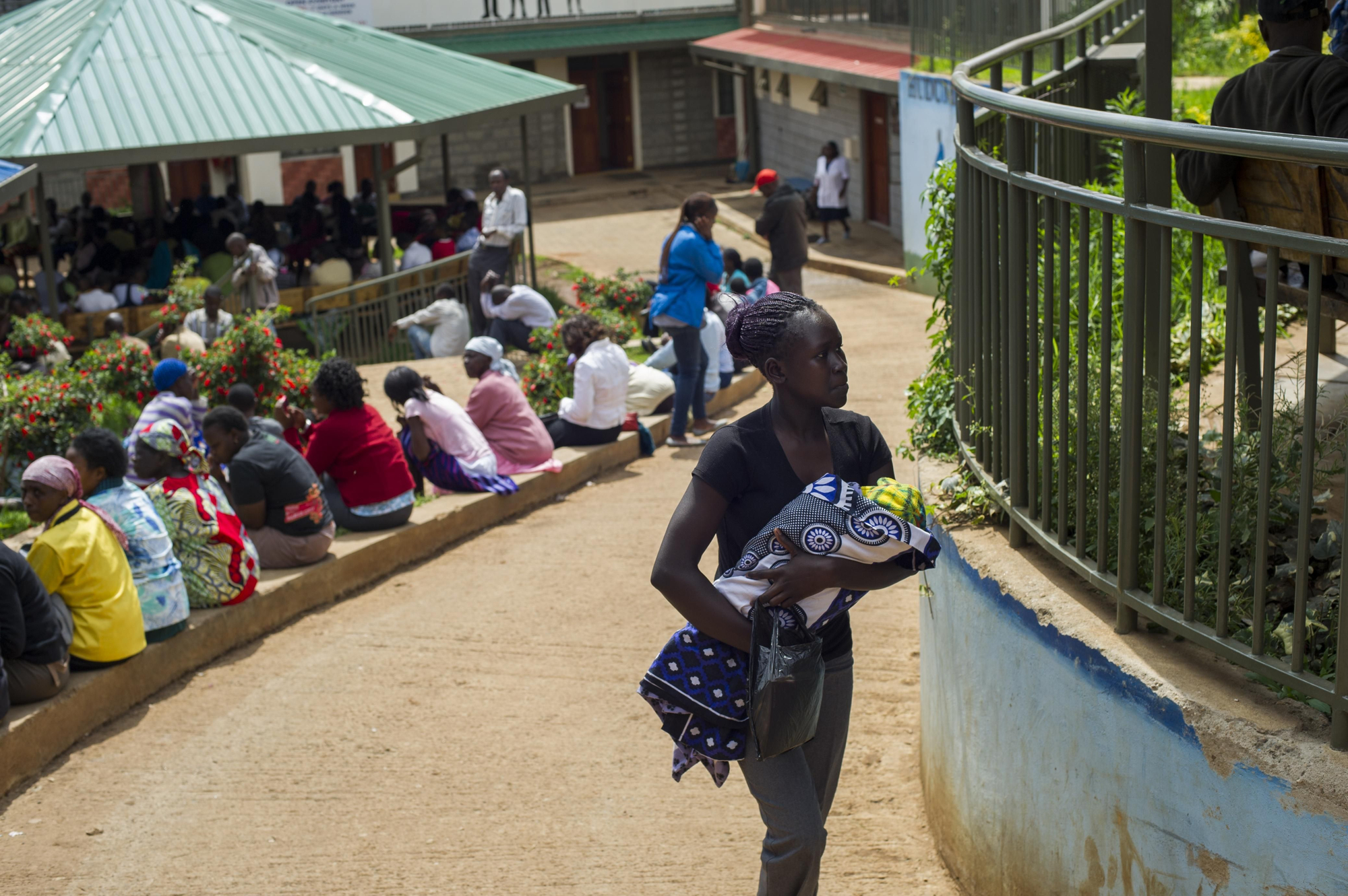 Una joven sale con su bebé de la clínica de MSF. En Kibera, el número de mujeres que mueren al dar a luz es más del doble que la de cualquier otro lugar de Kenia. Aparte de los servicios que presta MSF en el barrio, no existen servicios maternos gratuitos en Kibera.  Fotografía: Phil Moore