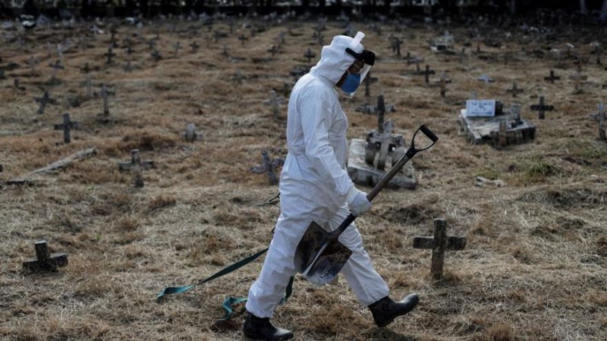 Un sepulturero camina por las tumbas después de finalizar el entierro de Nazareno Rodrigues Costa, de 72 años, que murió con sospecha de Covid-19, este miércoles, en el cementerio de Cajú, en Río de Janeiro (Brasil).