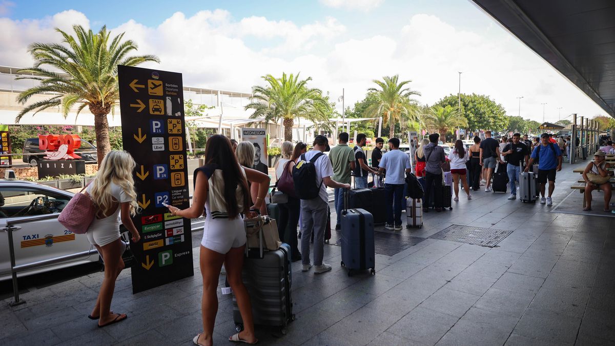 Diversos grups de turistes comporten les maletes mentre busquen un transport per dirigir-se a la seva primera destinació a l'illa