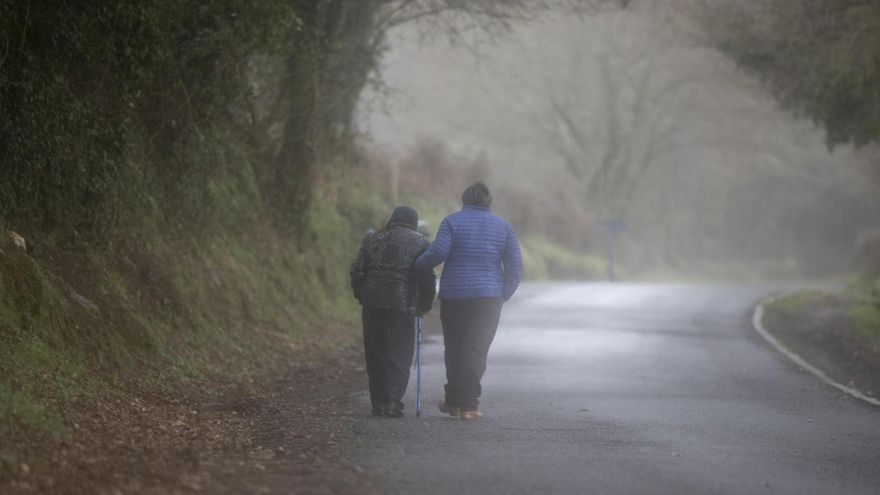 En la imagen de archivo, un anciano pasea con ayuda de su cuidadora en Lugo.