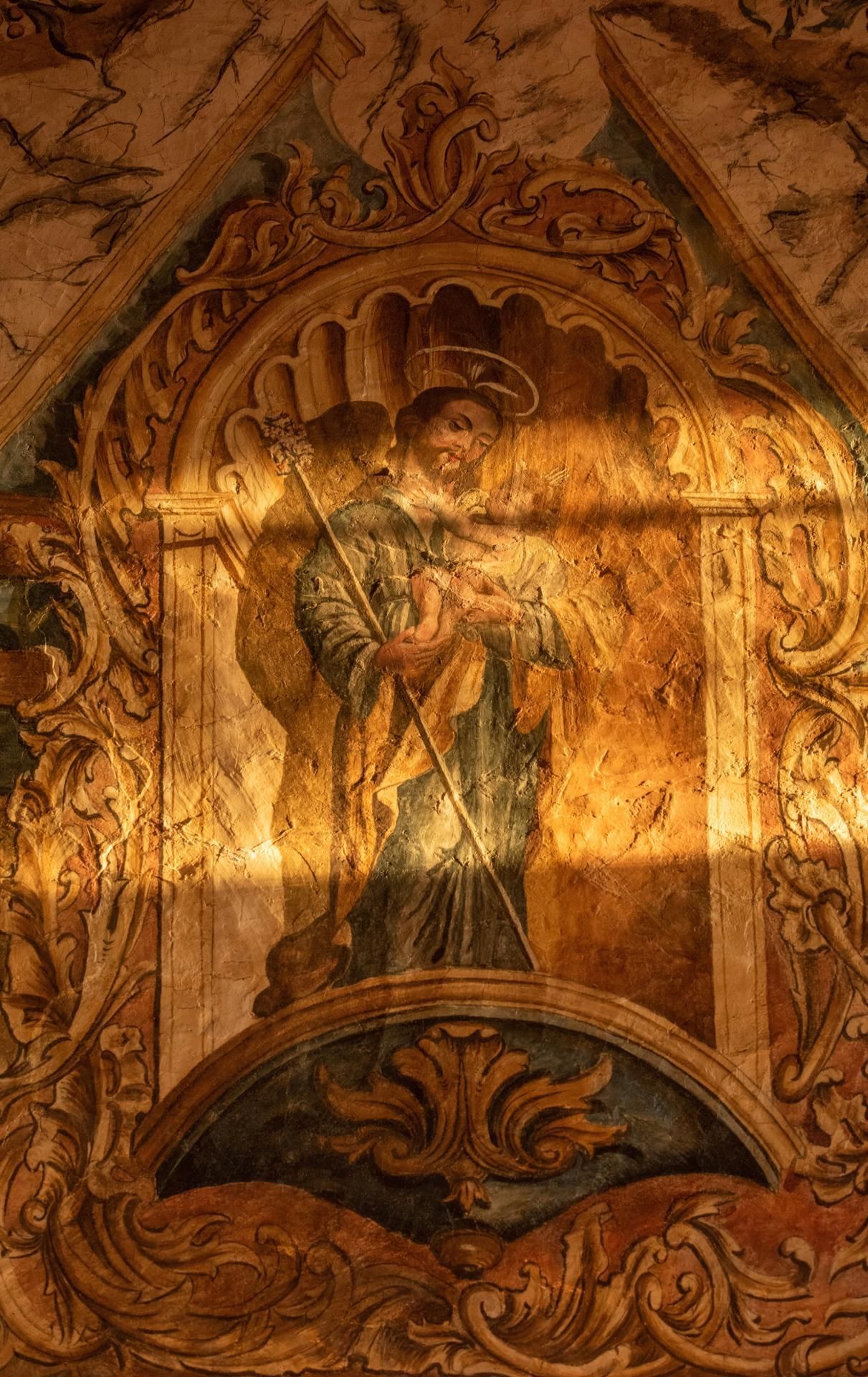 Detalle de las pinturas murales con la luz de las ventanas al atardecer