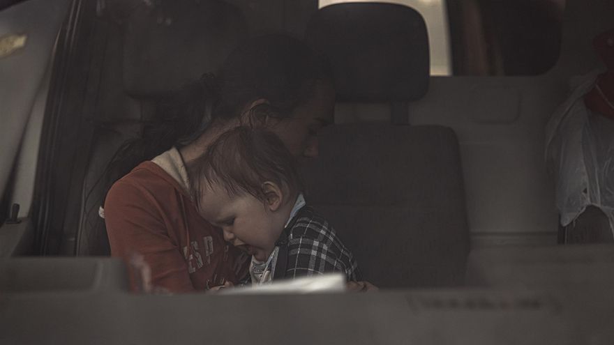Una mujer consuela a su hijo en su coche tras llegar a Zaporiyia desde Mariúpol a través de los corredores abiertos el domingo.