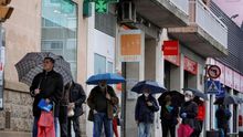 Varias personas hacen cola en una farmacia de Igualada (Barcelona), este lunes, cuando las 3.227 farmacias catalanas inician el reparto de las mascarillas compradas por la Generalitat para repartirlas entre la ciudadanía, que recibirá una por cada tarjeta sanitaria, cuando ya se planea la etapa postepidémica.