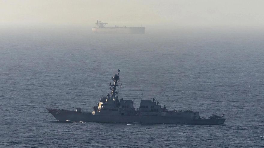 Fotografía tomada de la cuenta en X @CENTCOM del Comando Central de Estados Unidos de un destructor de misiles guiados estadounidense cerca de un buque de carga en el mar Arábigo