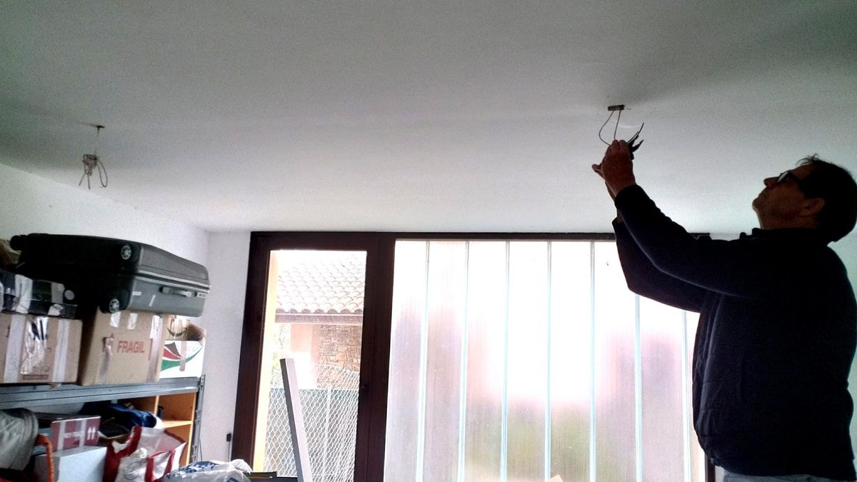 Fernando arregla una de las lámparas de su vivienda municipal de alquiler