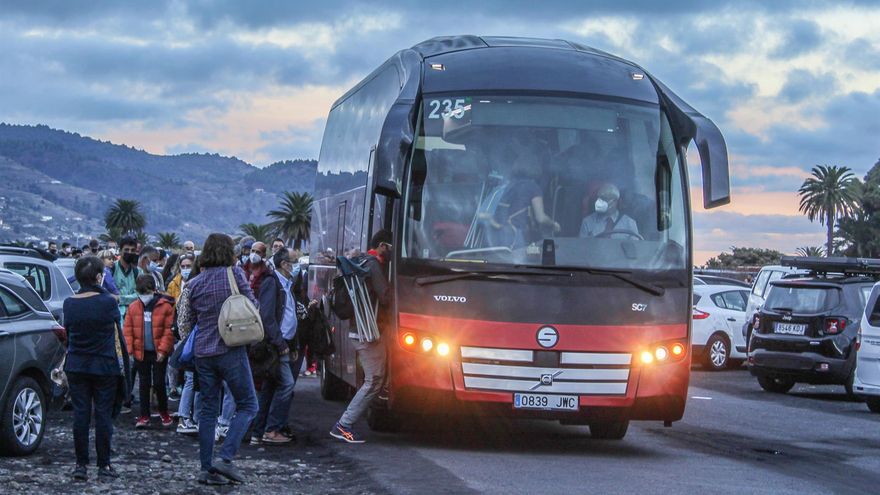 Cientos de personas hacen cola para desplazarse en los autobuses que las autoridades han dispuesto para acceder hasta la zona del volcán, este sábado en La Palma
