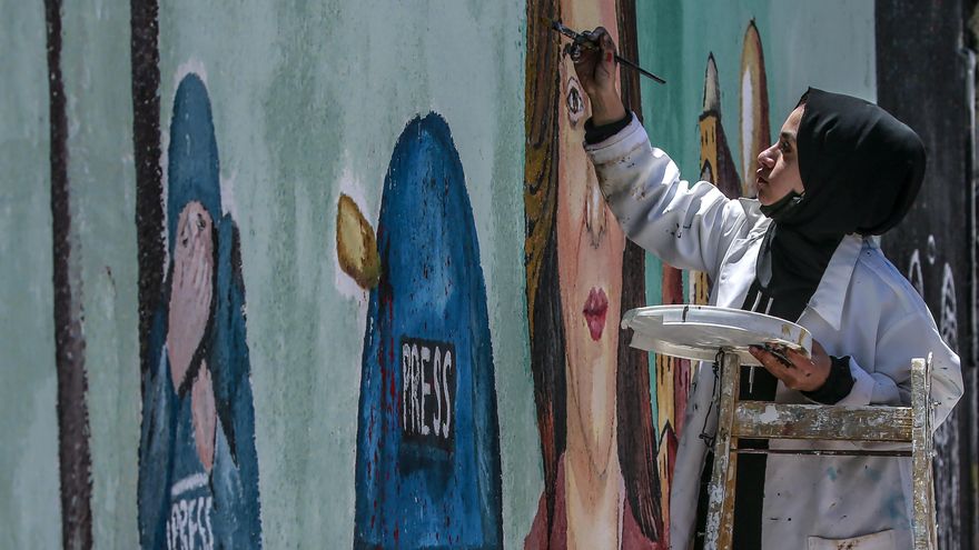 Una de las artistas palestinas pintando el mural en honor a Shireen Abu Akleh in Gaza