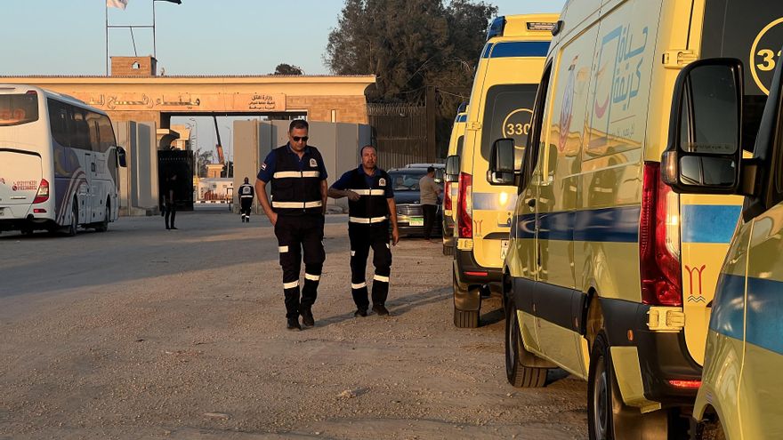 Trabajadores pasan cerca de ambulancias en el paso de Rafah entre la Franja de Gaza y Egipto este 4 de noviembre de 2023