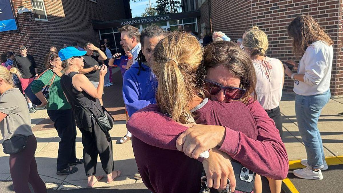 Padres de alumnos del colegio donde se produjo el tiroteo en Mineápolis (EEUU) se abrazan mientras esperan noticias de los niños.