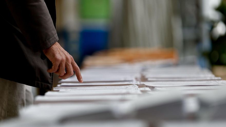 Un hombre observa las papeletas en un colegio electoral de Madrid este domingo durante las elecciones municipales y autonómicas.