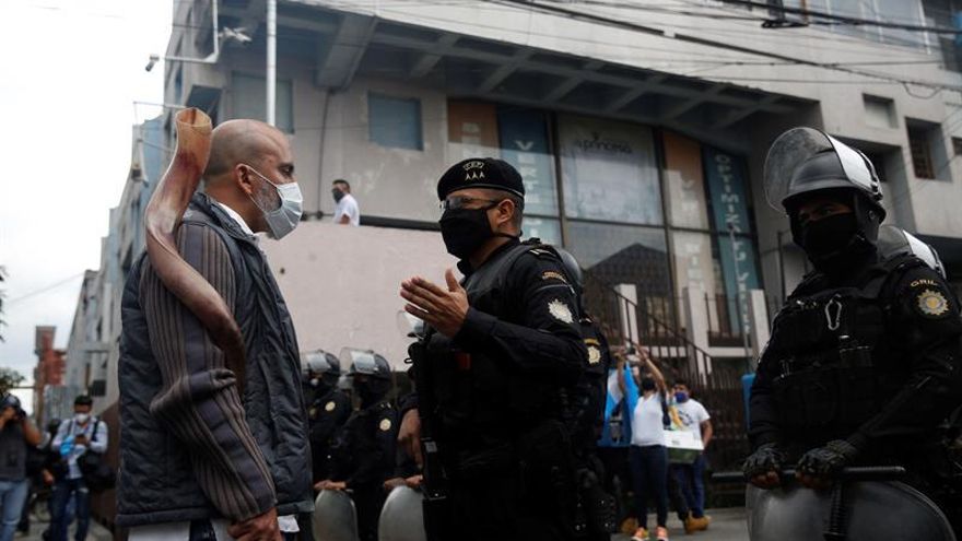 Manifestantes discuten con la policía, quienes tratan de impedir que lleguen los vehículos al Palacio Nacional, durante una protesta este jueves, para exigir el cese del confinamiento al Gobierno, en Ciudad de Guatemala (Guatemala).