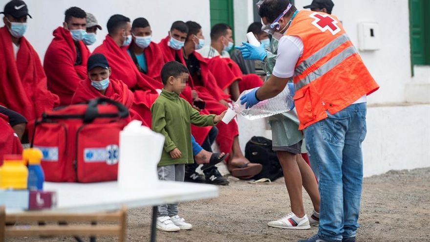 Miembros de los equipos de emergencias ofrecen agua y algo de comida a los 29 migrantes que han llegado en patera este viernes a la costa de Caleta de Caballo, en el norte de Lanzarote, entre ellos una mujer y seis menores.