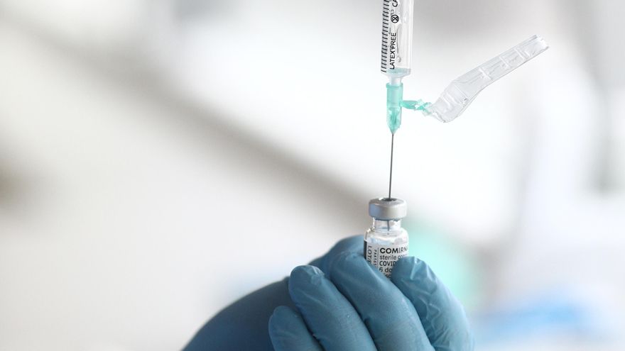 Archivo - Un sanitario prepara una de las dosis de la vacuna Pzifer antes de suministrarsela a un anciano