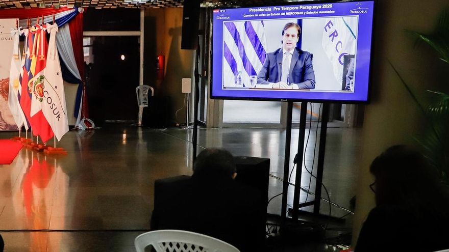 Periodistas y funcionarios de presidencia y cancillería observan por televisión la intervención de Luis Lacalle Pou presidente de Uruguay durante la Cumbre de Jefes de Estado del Mercosur y Estados Asociados este jueves en el Salón de Convenciones del Banco Central del Paraguay en Asunción (Paraguay).